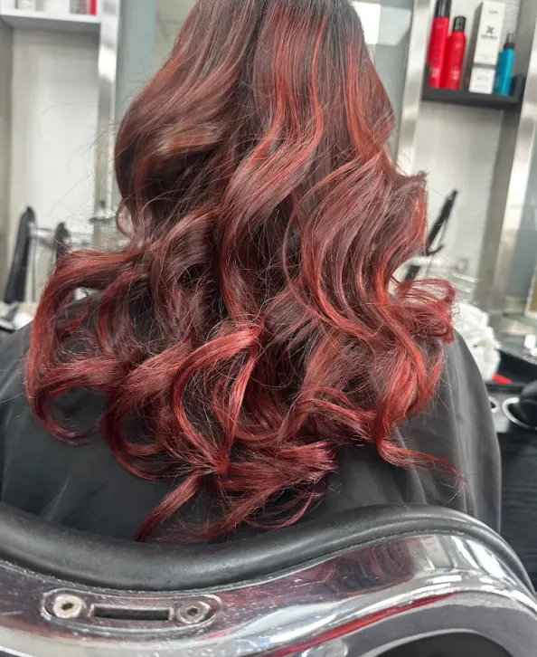 Glossy curled red colour result created at Naz Hair and Beauty