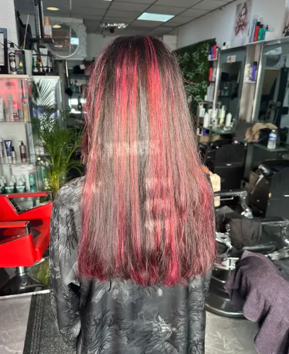 Long smooth dark hair with vivid red ribbon highlights at Naz Hair and Beauty